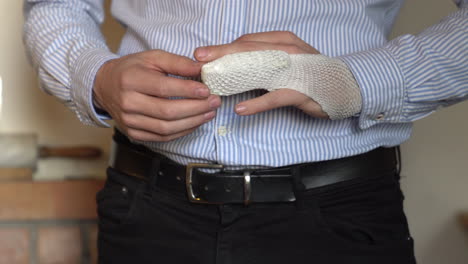 man checking hes broken finger, fractured finger fixed with bandage