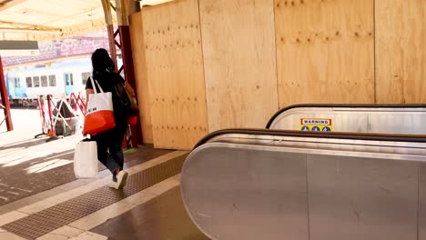 woman with bags using an escalator