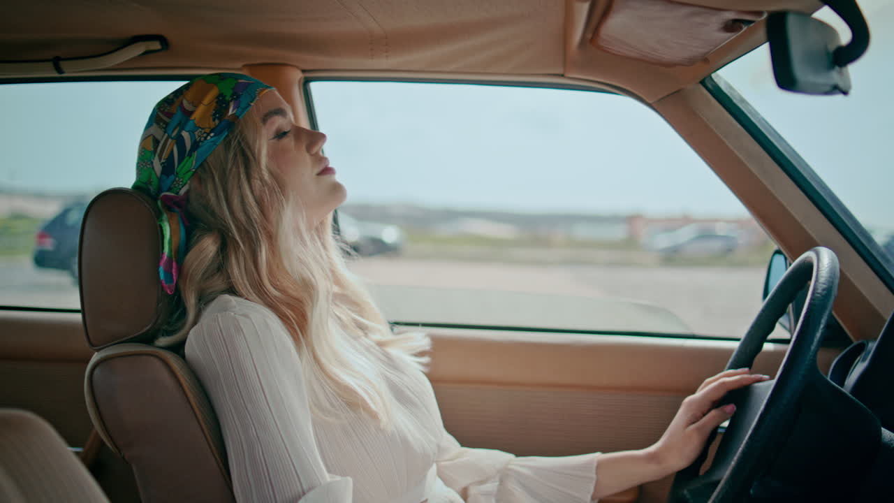 스터가 벤다나에 앉아있는 레트로 자동차 클로즈업. 차에서 휴식을 취하는 평온한 여성