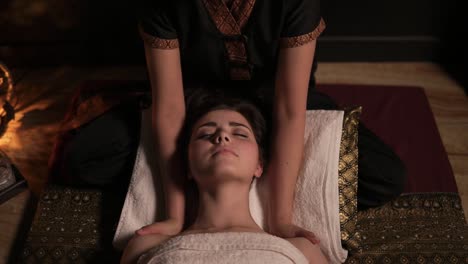 Beautiful-woman-having-thai-massage-of-her-neck-and-shoulders-in-spa.-Unrecognizable-female-masseuse.-Slow-Motion-shot