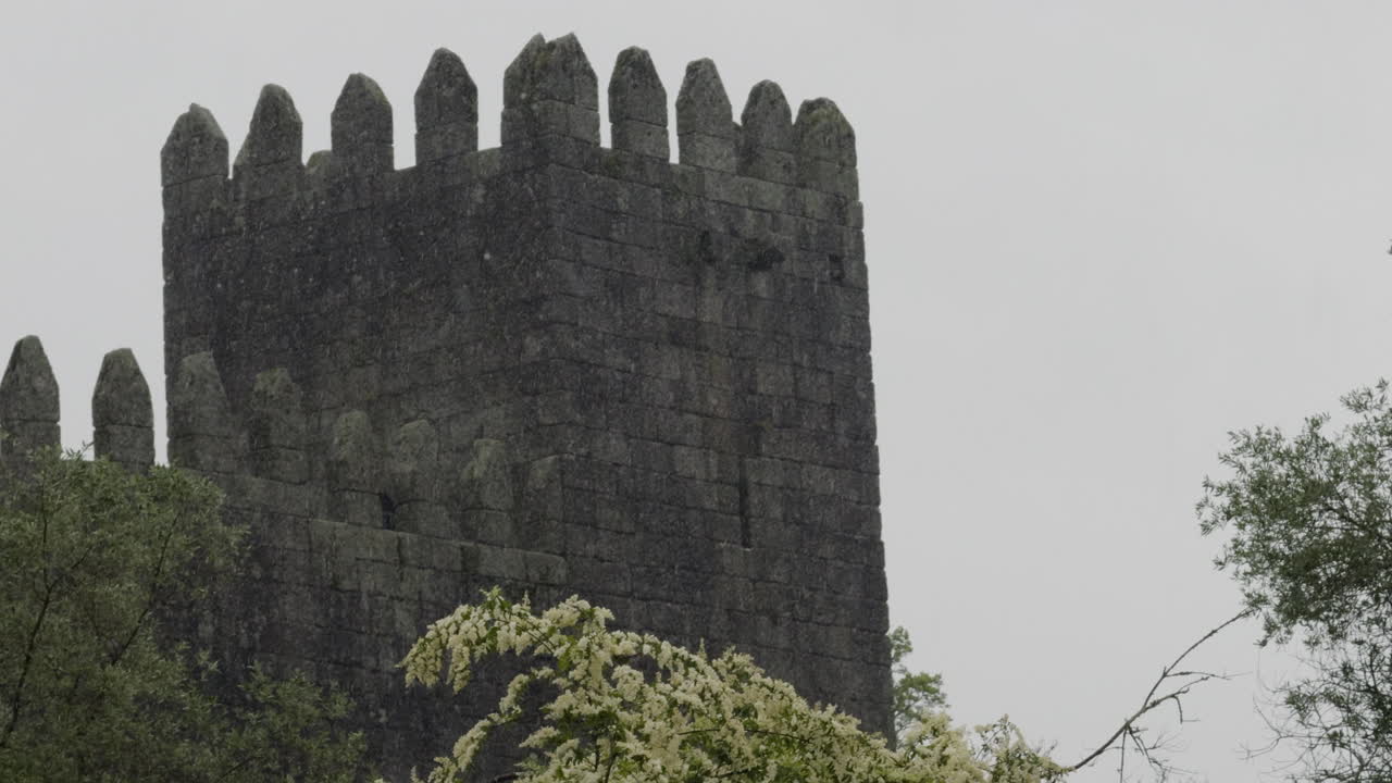 Fortress Stone Tower On A Rainy Day Surrounded By Trees At Guimaraes Castle