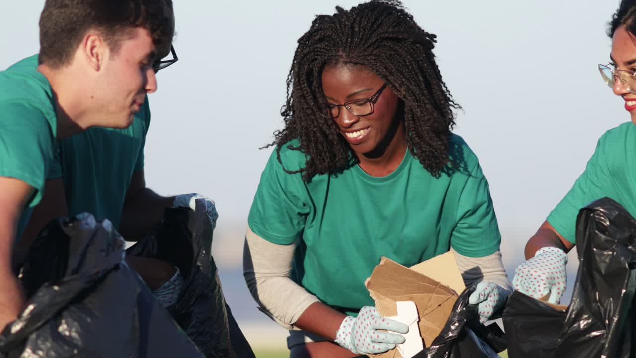Smiling volunteers sorting garbage