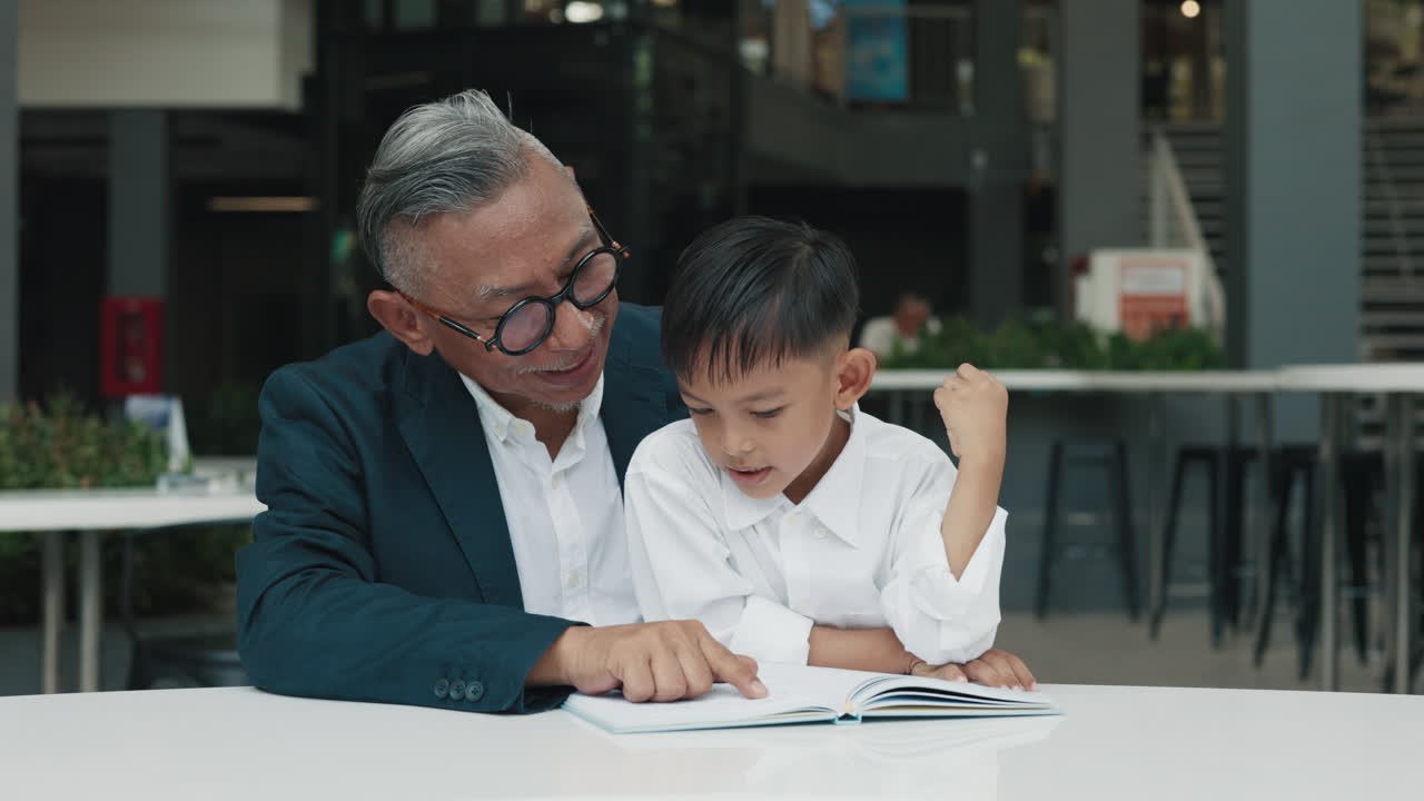 Grandfather reading with his grandson