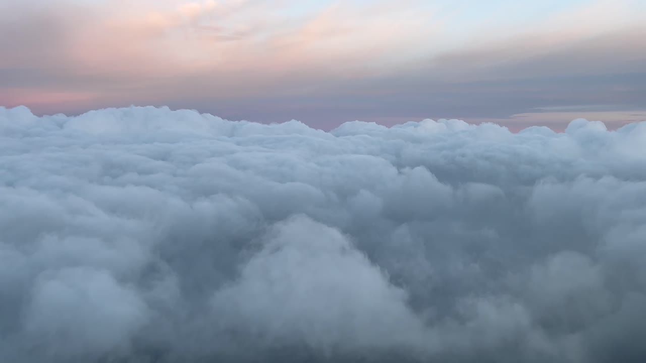pov volando en un cielo celestial lleno de colores pastel disparado al amanecer desde una cabina de avión