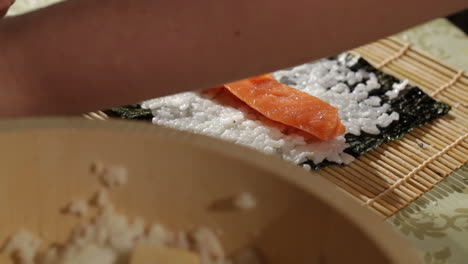 making sushi rolls with salmon and philadelphia cheese