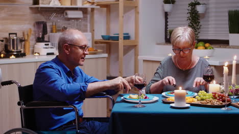 man in wheelchair dining with wife