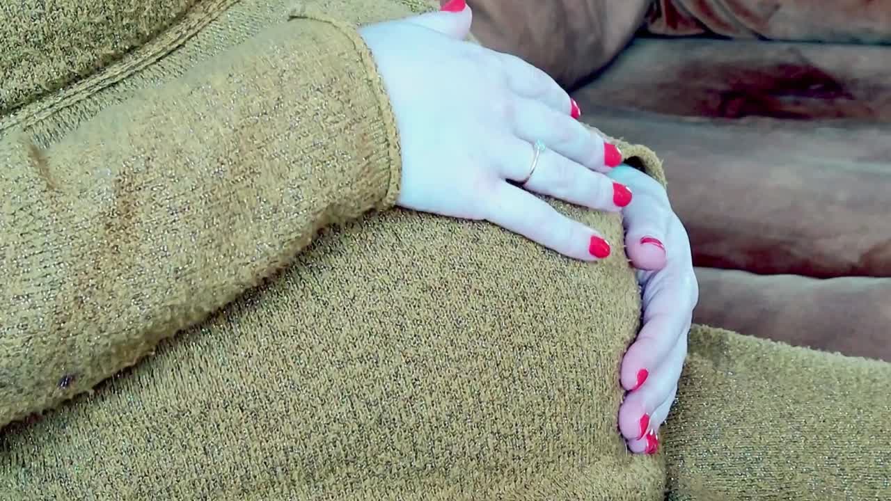 mujer embarazada casada acariciando su vientre en un sofá sintiéndose enamorada de su hijo por nacer