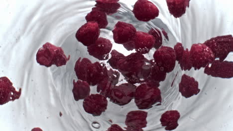 juicy raspberry beverage spinning top view. cold drink with pink berries vortex