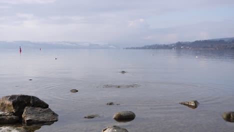 Person,-Die-Steine-Auf-Die-Wasseroberfläche-Wirft,-Hüpft-Und-Hüpft---Zeitlupe