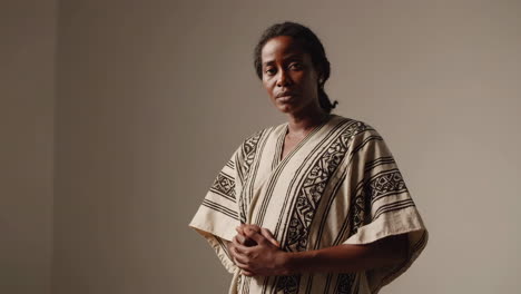a woman in a patterned garment gesturing with her finger pointed upwards, with varying facial expressions