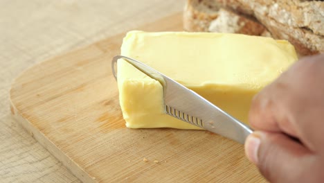 cortar la mantequilla en una tabla de cortar de madera