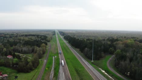 semi trucks driving on american style highway in high angle drone view