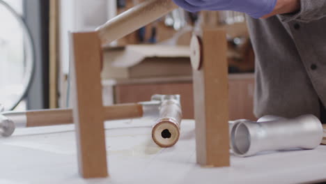 primer plano de un artesano masculino en un taller de montaje de un marco de bicicleta de bambú sostenible construido a mano