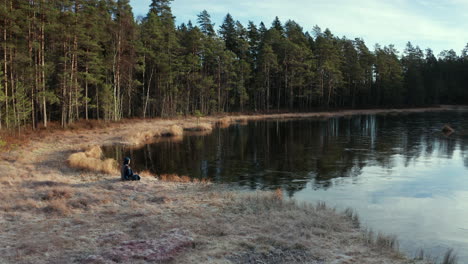 stunning aerial rise - an ice bather sits in mental preparation for his daily plunge