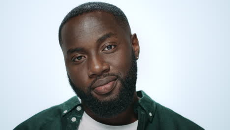 portrait of playful african american man flirting on camera in studio.