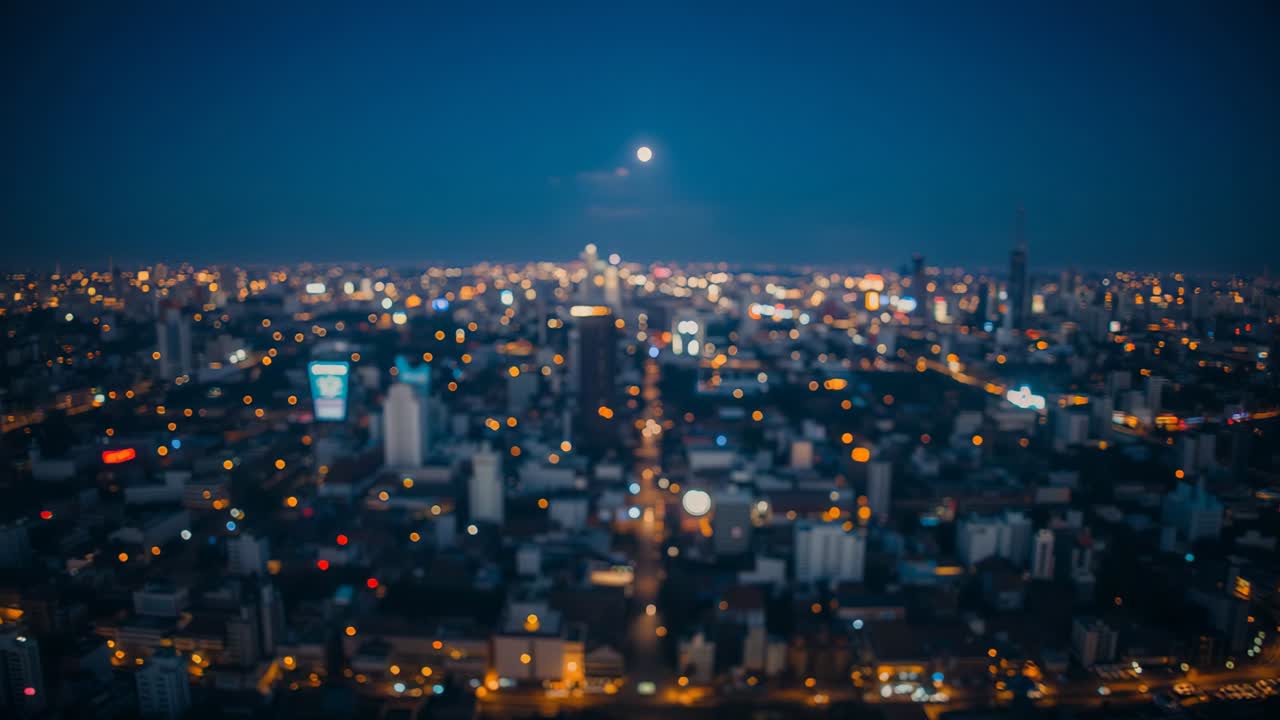 Full moon rising causing camera holding view over blurred cityscape at night, with blinking windows