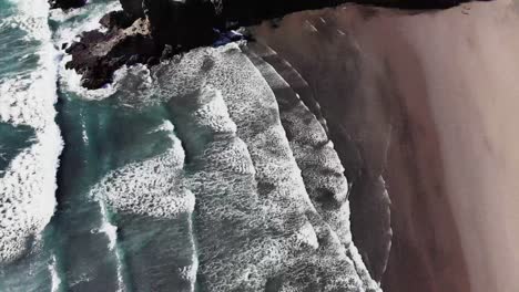 Vista-De-Pájaro-Volando-Un-Dron-Sobre-Las-Olas-En-La-Playa-De-Piha-En-Nueva-Zelanda