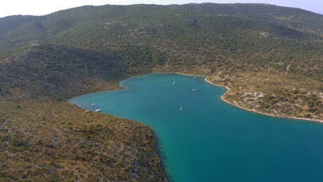 aerial: slow panning drone shot of planitis bay of the island of kira panagia in sporades, greece with amazing turquoise and emerald crystal clear water