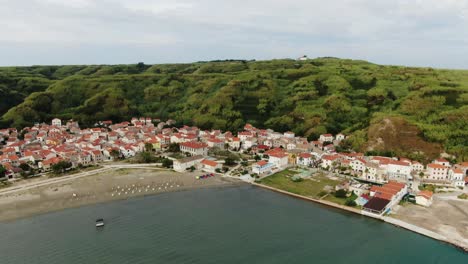 a drone shot of an island village near a sandy beach