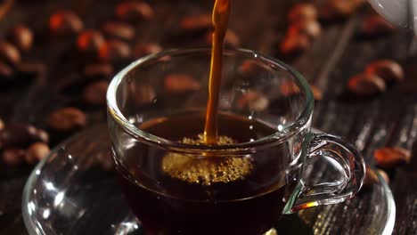 pouring coffee into a glass cup with coffee beans