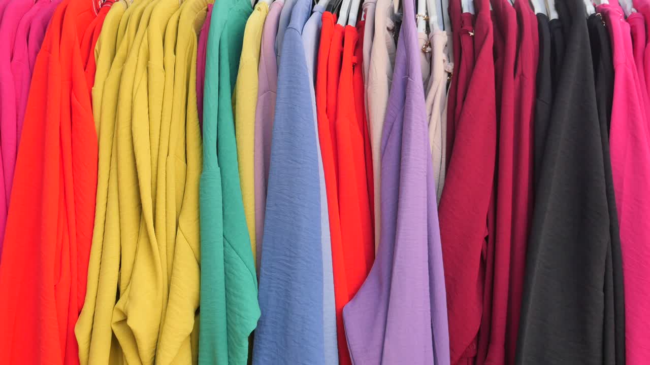 다채로운 옷 들 이 선반 에 전시 되어 있다