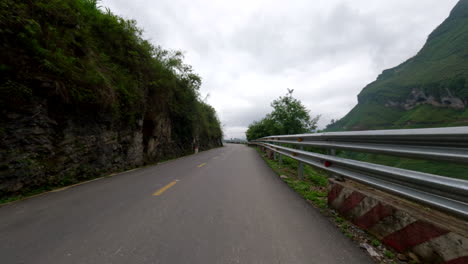 scooter passing through mountain road at popular ha giang loop in vietnam. pov shot