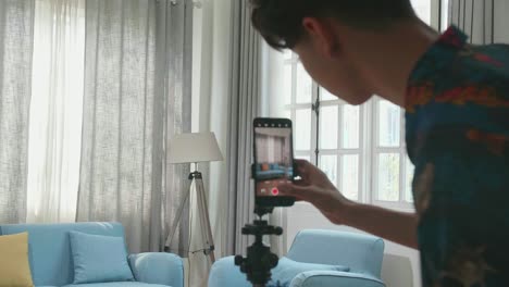 man dancing and recording a video at home