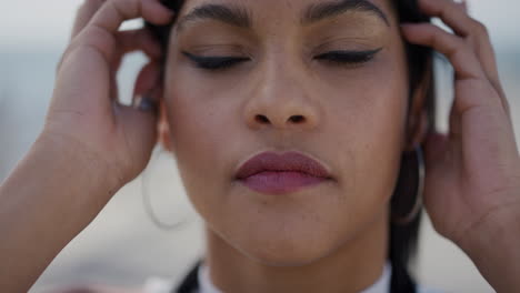 close up portrait beautiful hispanic woman running hand through hair wind blowing looking serious contemplative healthy skin feminine beauty slow motion