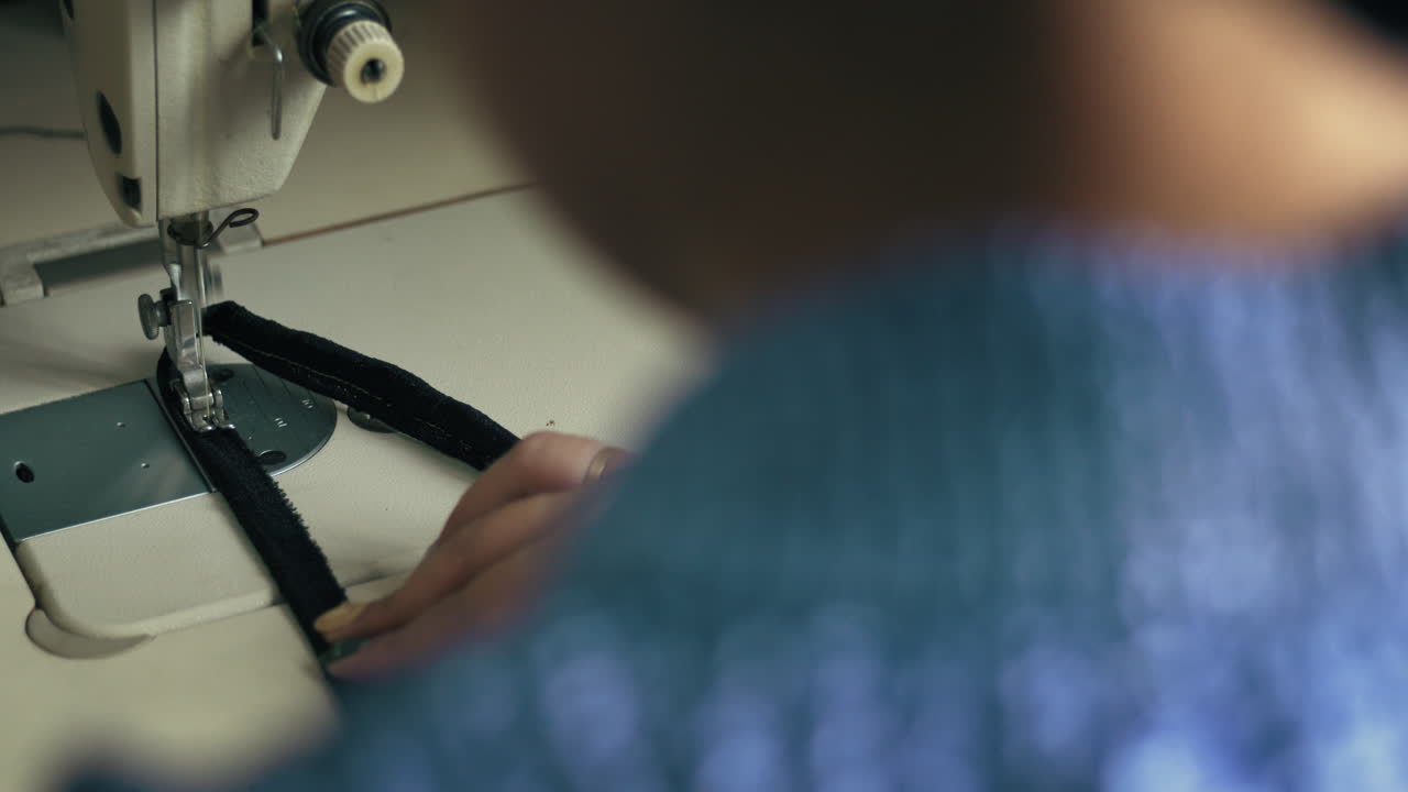 패션 디자이너가 바느질 기계에서 일하고 있습니다.