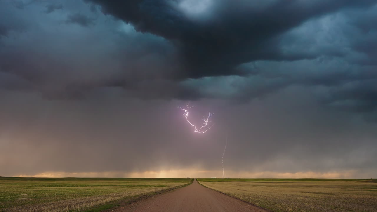 Intense Lightning Bolts Illuminate Dark Storm Clouds Over Open Plains