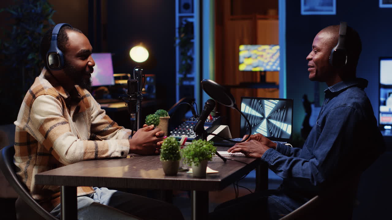 Host adjusting analog mixer while listening to man invited in studio sharing facts