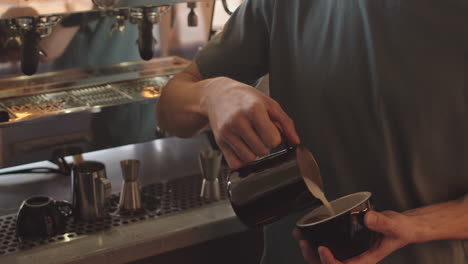 professional barista making cappuccino in coffeeshop