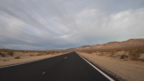 Conduciendo-A-Lo-Largo-De-Un-Camino-Recto-Recién-Pavimentado-A-Través-De-La-Vasta-Tierra-Baldía-Del-Desierto-De-Mojave---Hiperlapso