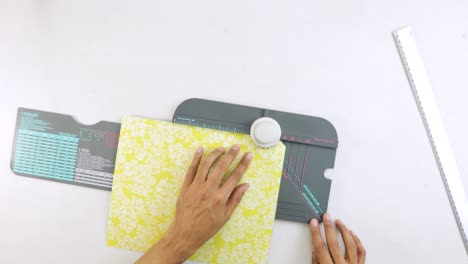 punching cutouts in yellow paper with ornaments on 123 punch board