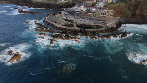 volcanic pools of porto moniz in madeira potrugal fottage with drone of cliffs, ocean, atural bathing spots, houses filmed at sunset