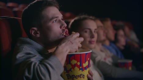 hombre grosero comiendo palomitas de maíz en el cine. modales groseros en la sala de cine