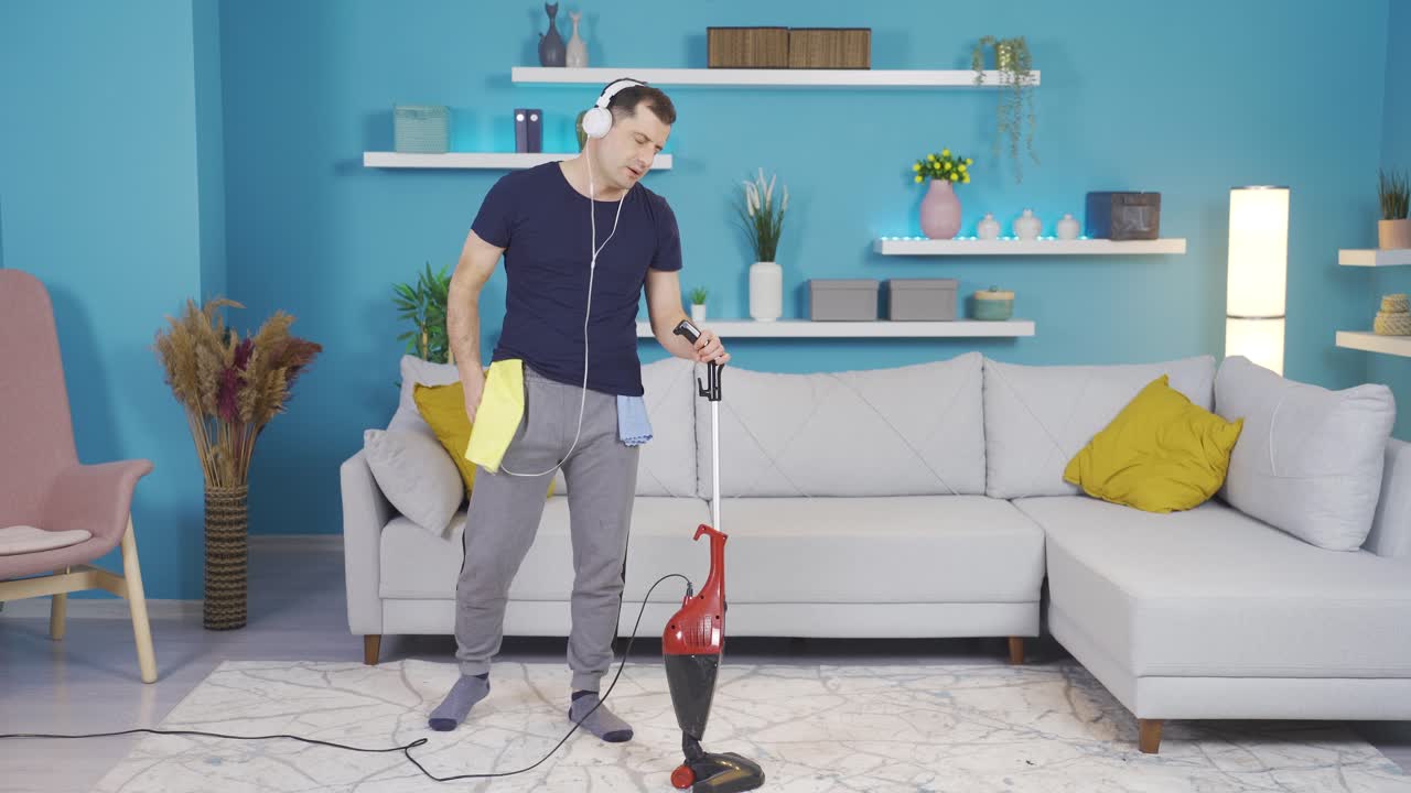 hombre limpiando la casa mientras escucha música con auriculares.