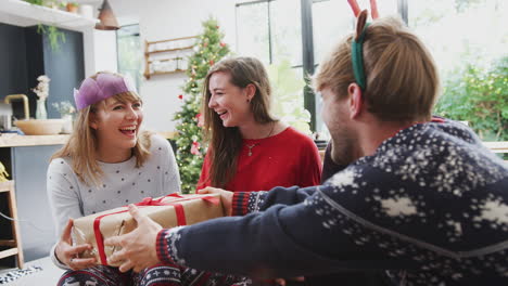 gay friends at home exchanging gifts on christmas day together