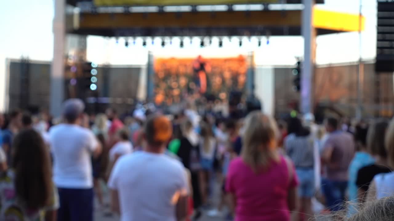 Concerto sul palco. Folla di persone e musicisti sulla scena. Fuori fuoco