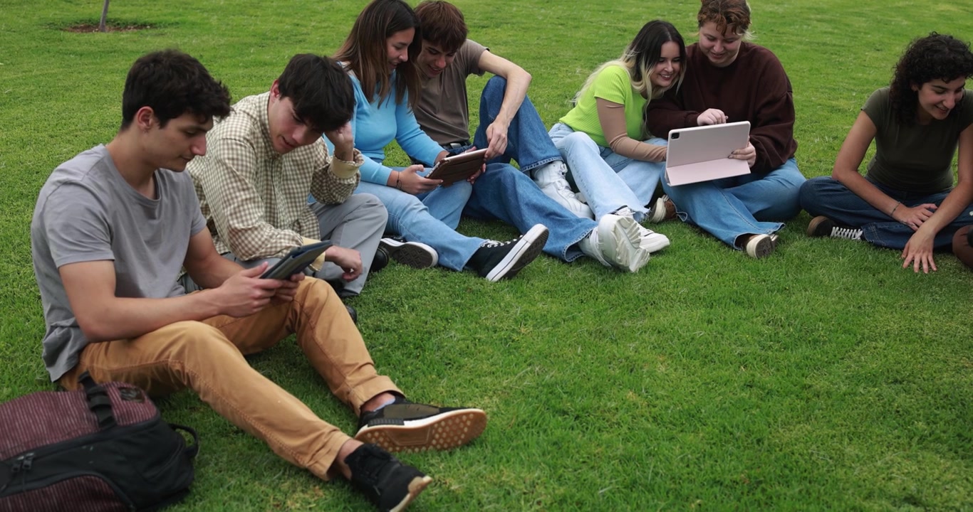 Group of Students Using Tablets Together on Grass