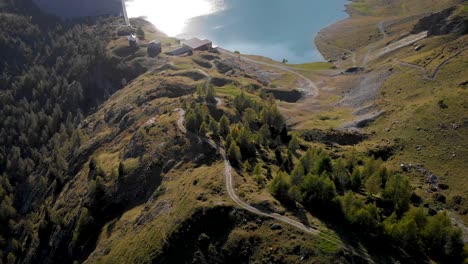 Vista-Aérea-Del-Lago-De-Salanfe-Y-Su-Presa-Hidroeléctrica-En-Valais,-Suiza,-En-Un-Soleado-Día-De-Otoño-En-Los-Alpes-Suizos-Con-Una-Vista-Panorámica-De-Los-Picos-Y-Acantilados-Alpinos-Circundantes.