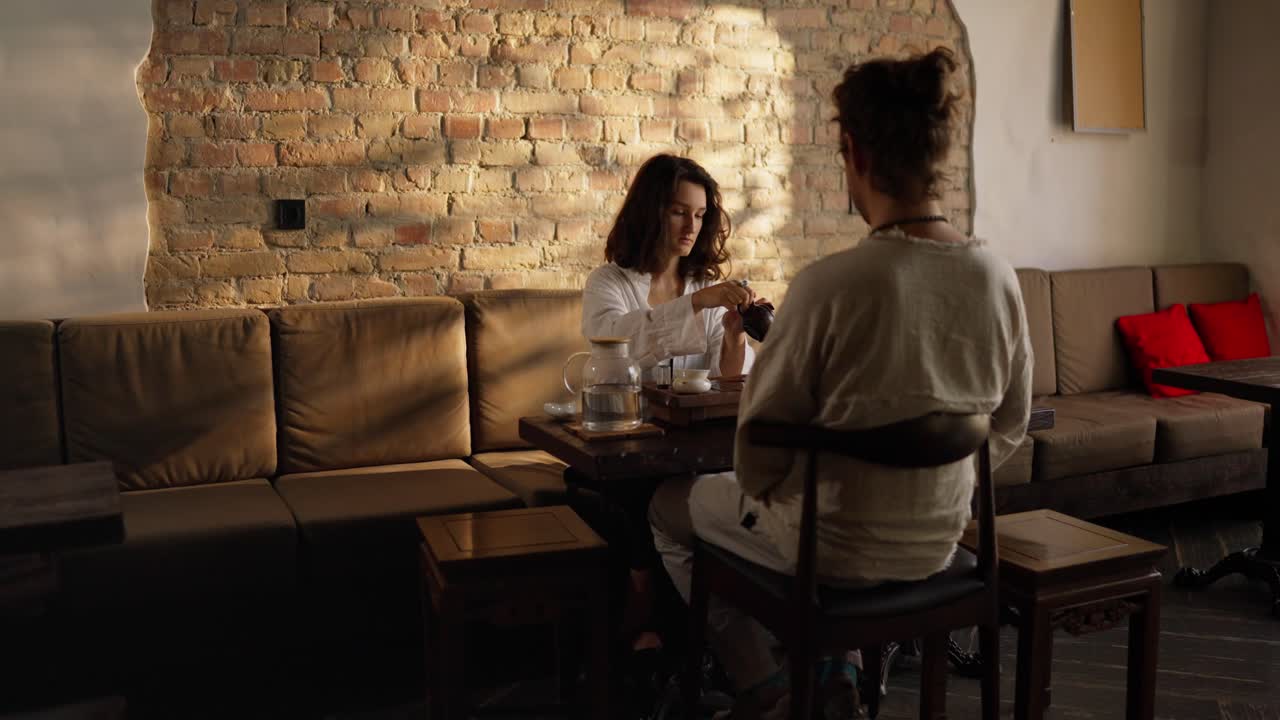 Casal apreciando uma cerimônia do chá em um café.