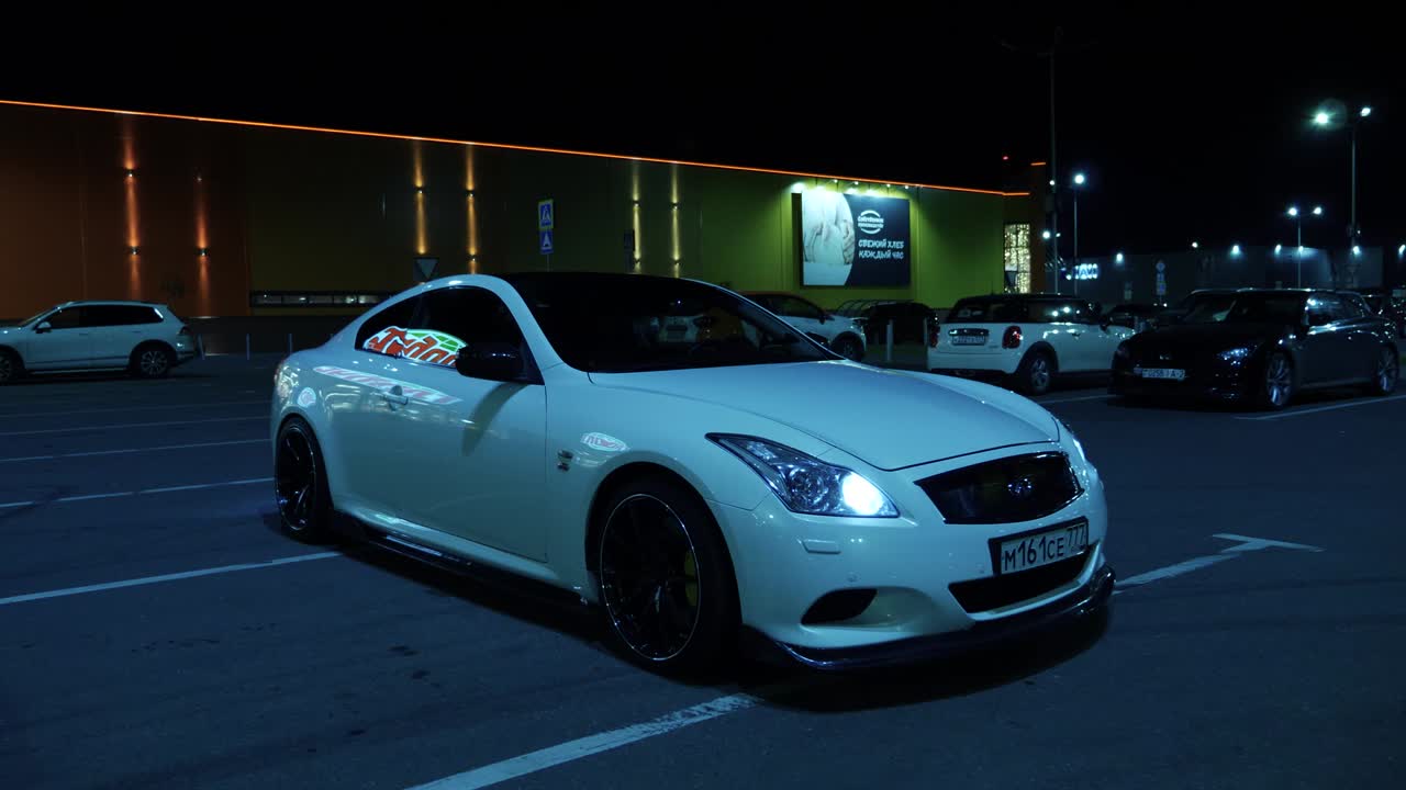 Coches en un estacionamiento por la noche.