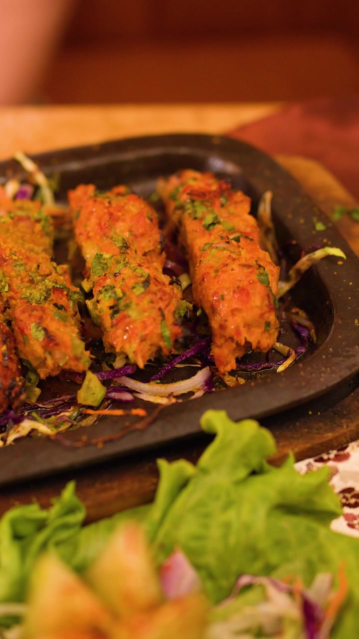 Henkilö syömässä sizzler-kebabia haarukalla ravintolassa