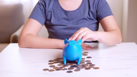 concepto de ahorro de dinero, mujer asiática mano poniendo moneda moneda en la alcancía