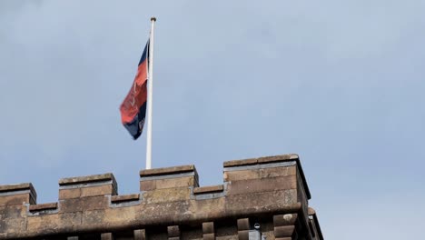 flag of macleod clan waving on dunvegan castle tower in scotland