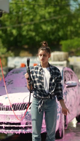 woman washing a car at a self-service car wash