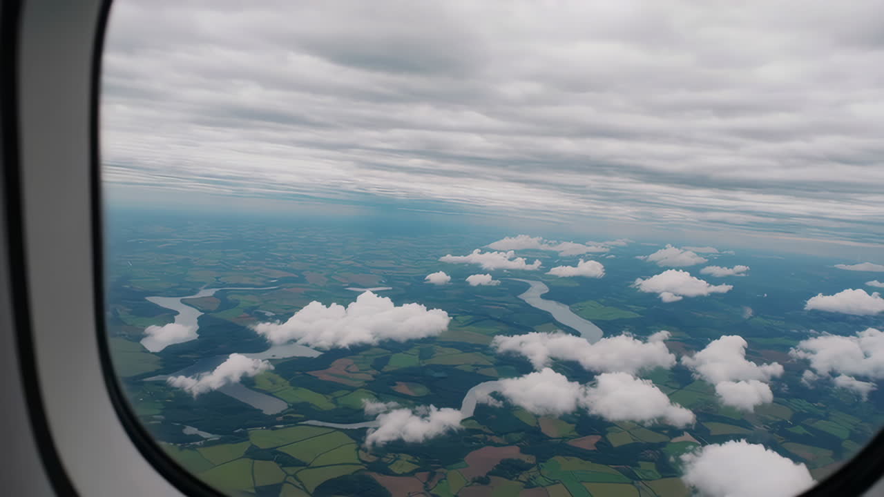 Aerial View of Rivers and Fields Through an Airplane Window on a Cloudy Day