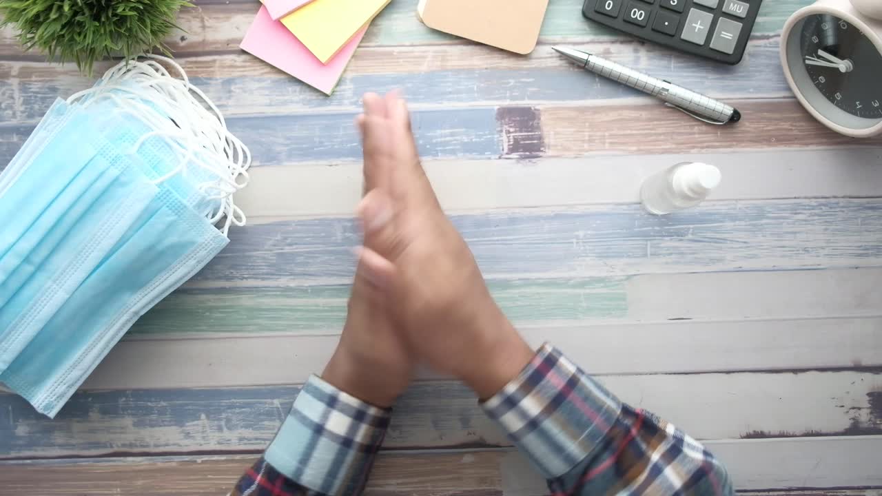 lavado de manos con desinfectante y máscaras faciales en un escritorio