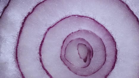 texture red onion rings rotating, close-up top view. harvested  healthy food background with vegetable of rich vitamin. sweet red spanish onion macro shot. food background closeup sliced purple onion